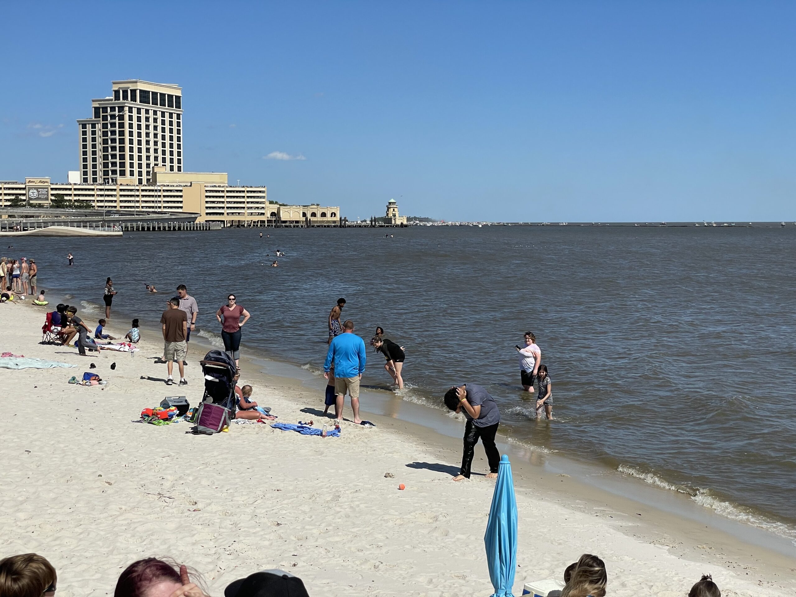 Coastal highway view near Biloxi casinos with palm trees, beach, and traffic along Highway 90