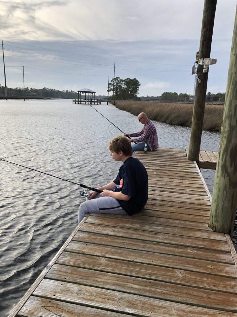 fishing from a dock or pier is a great way to start.  Image of two people fishing from a dock